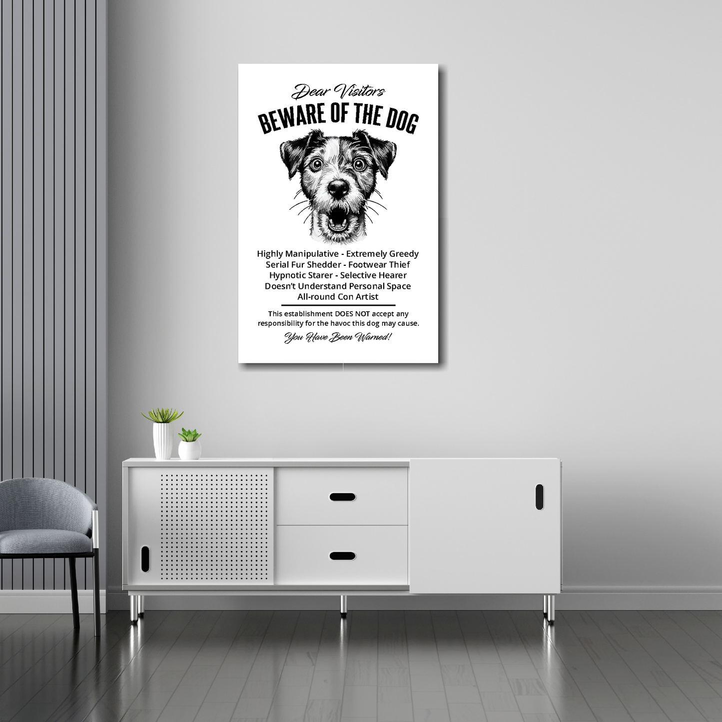 20 inch by 30 inch canvas print of a funny Jack Russell 'Beware of the Dog' notice. Mounted on a gray wall above a white sideboard.