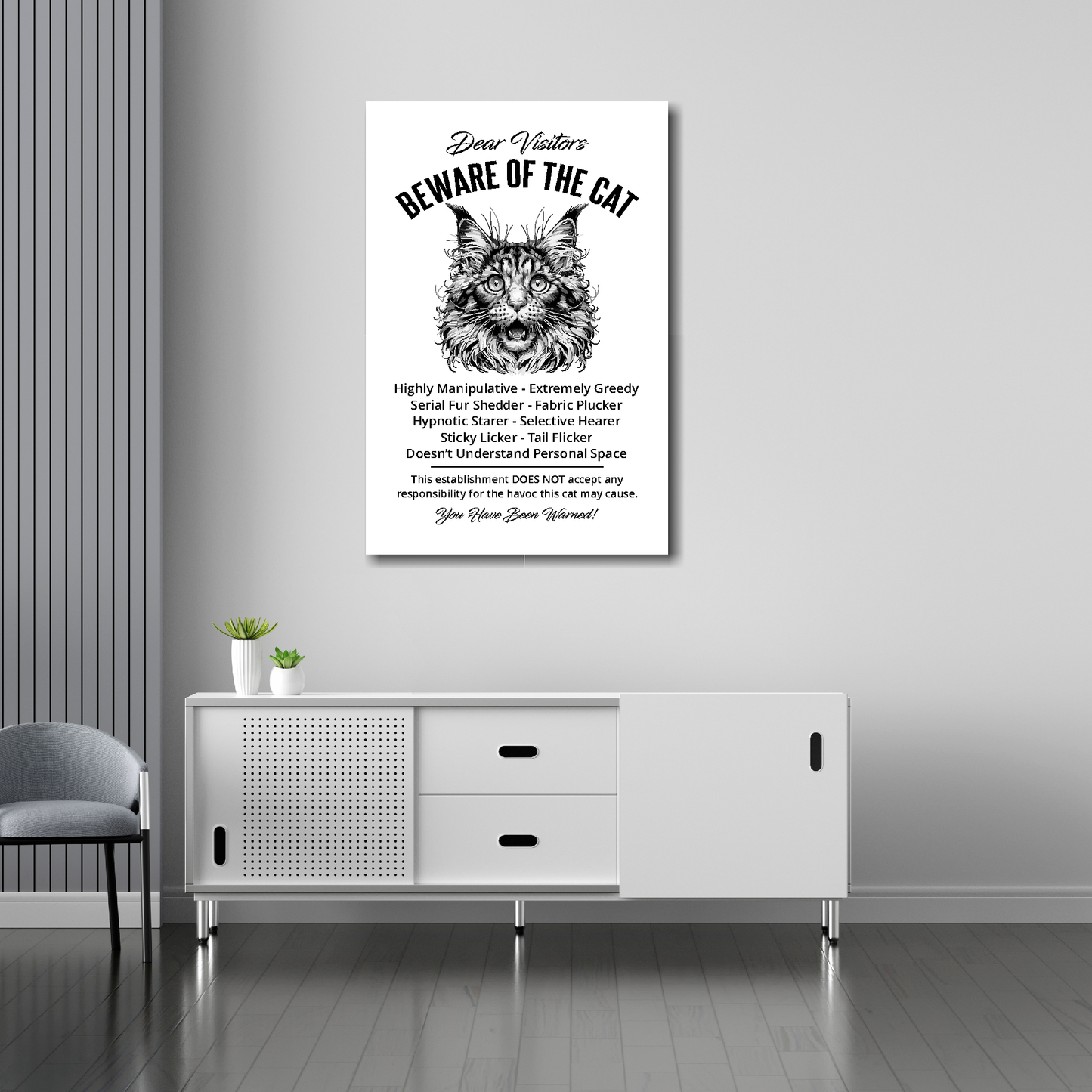 20 inch by 30 inch canvas print of a funny Maine Coon 'Beware of the cat' notice. Mounted on a gray wall above a white sideboard.