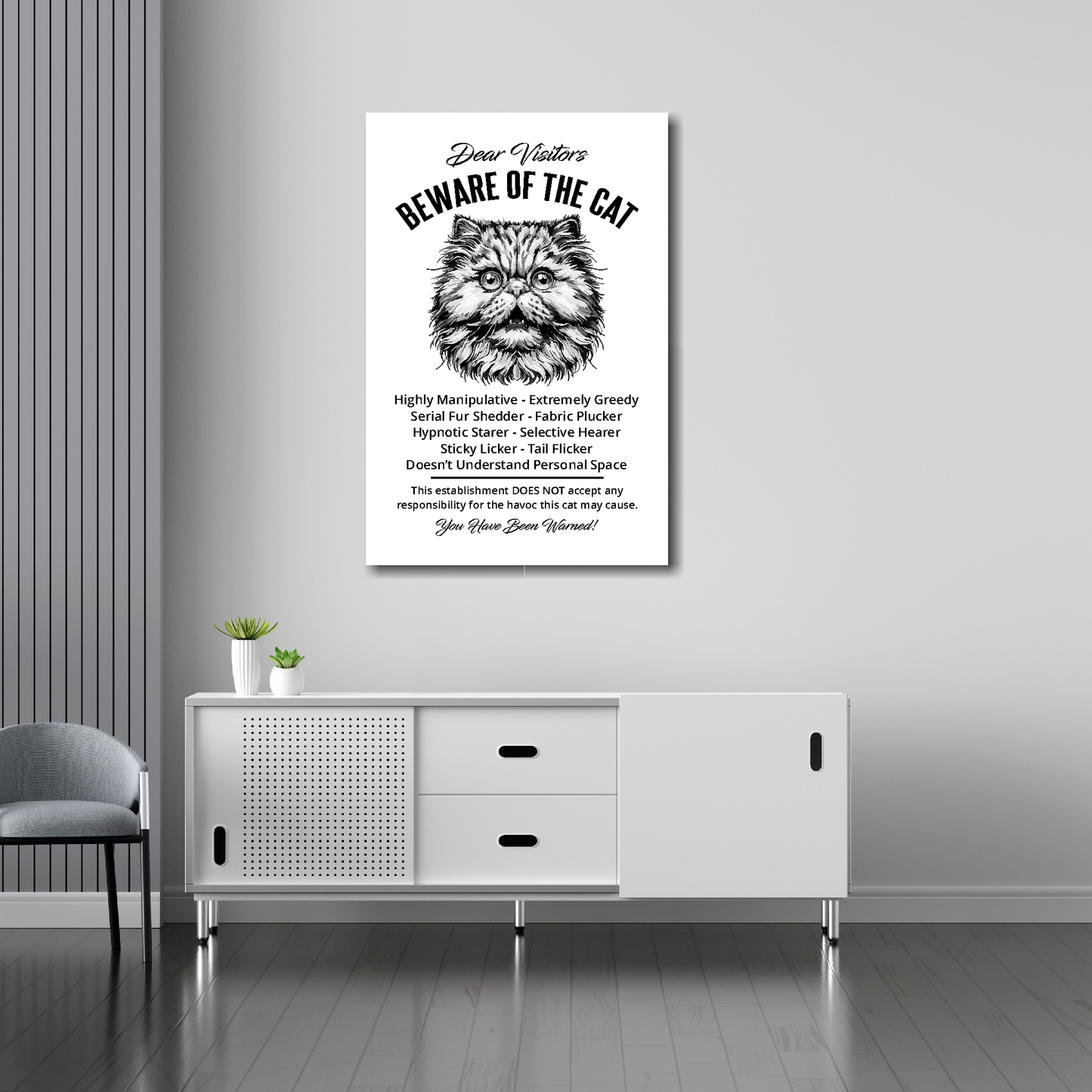 20 inch by 30 inch canvas print of a funny Persian 'Beware of the cat' notice. Mounted on a gray wall above a white sideboard.