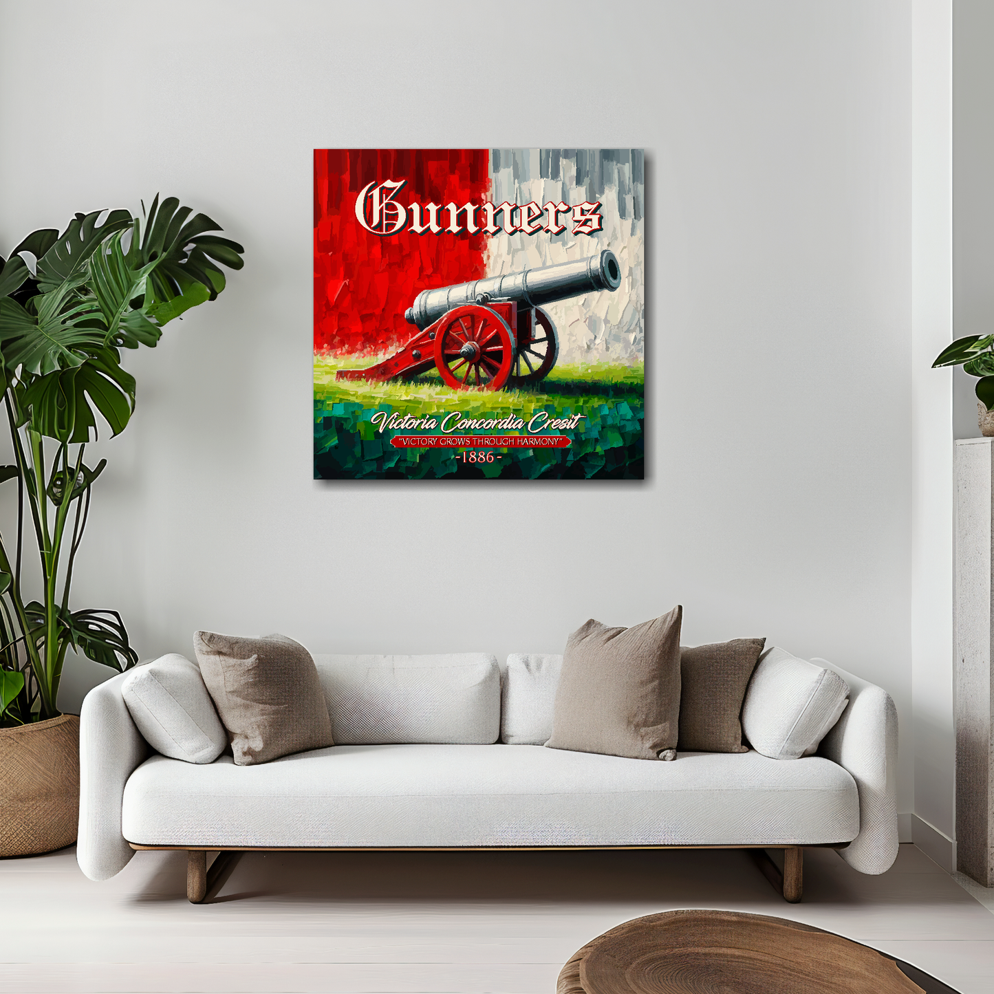 Arsenal inspired canvas wall art. A large cannon centred on a red and white backround. The word Gunners above, Victoria Concordia Cresit, 'Victory Grows Through Harmony' 1886 text below. Mounted on a white painted wall above a white sofa.