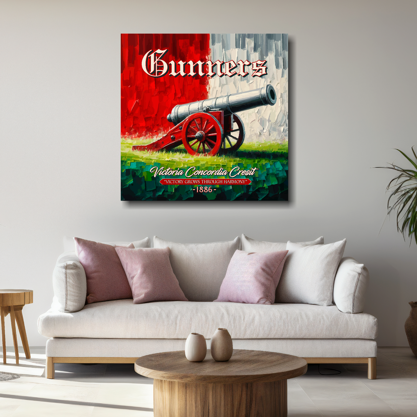 Arsenal inspired canvas wall art. A large cannon centred on a red and white backround. The word Gunners above, Victoria Concordia Cresit, 'Victory Grows Through Harmony' 1886 text below. Mounted on a grey painted wall above a white sofa.