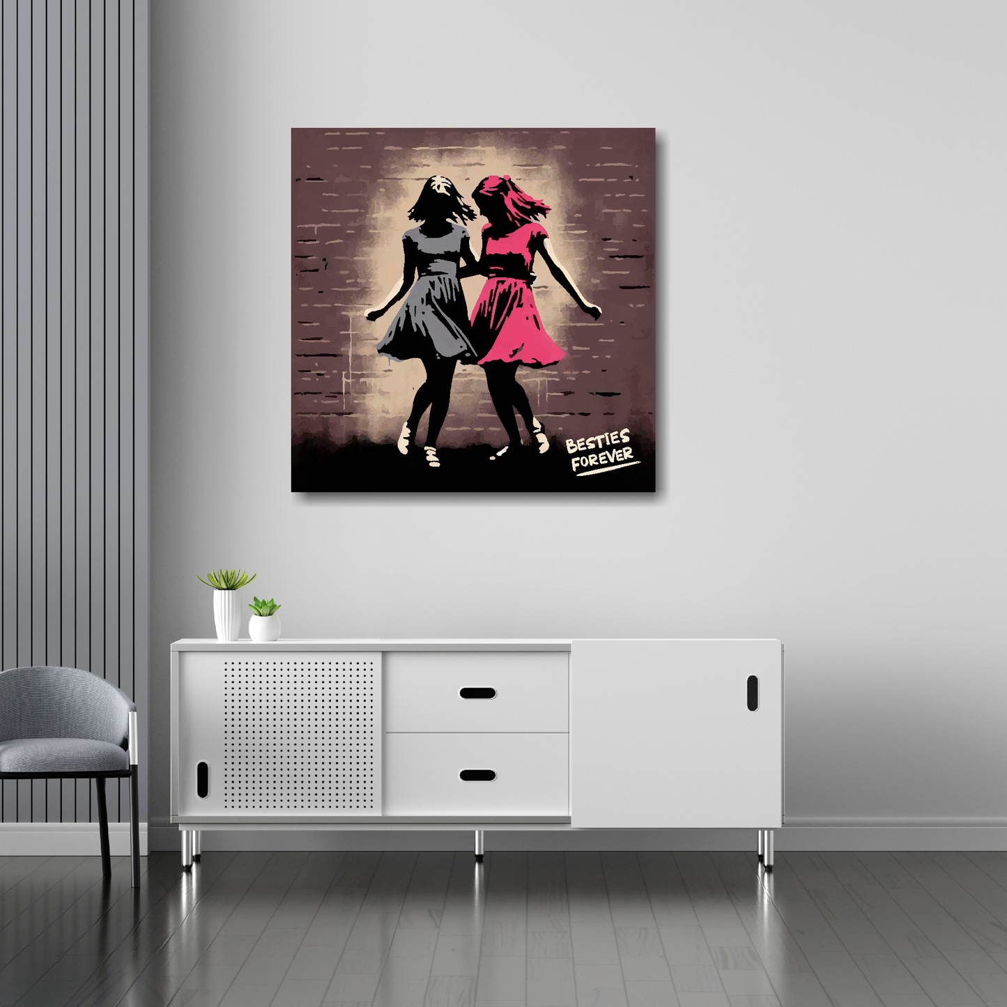 30 inch by 30 inch square canvas featuring a retro painting of two girl best friends dancing. Mounted on a white wall above a white sideboard.