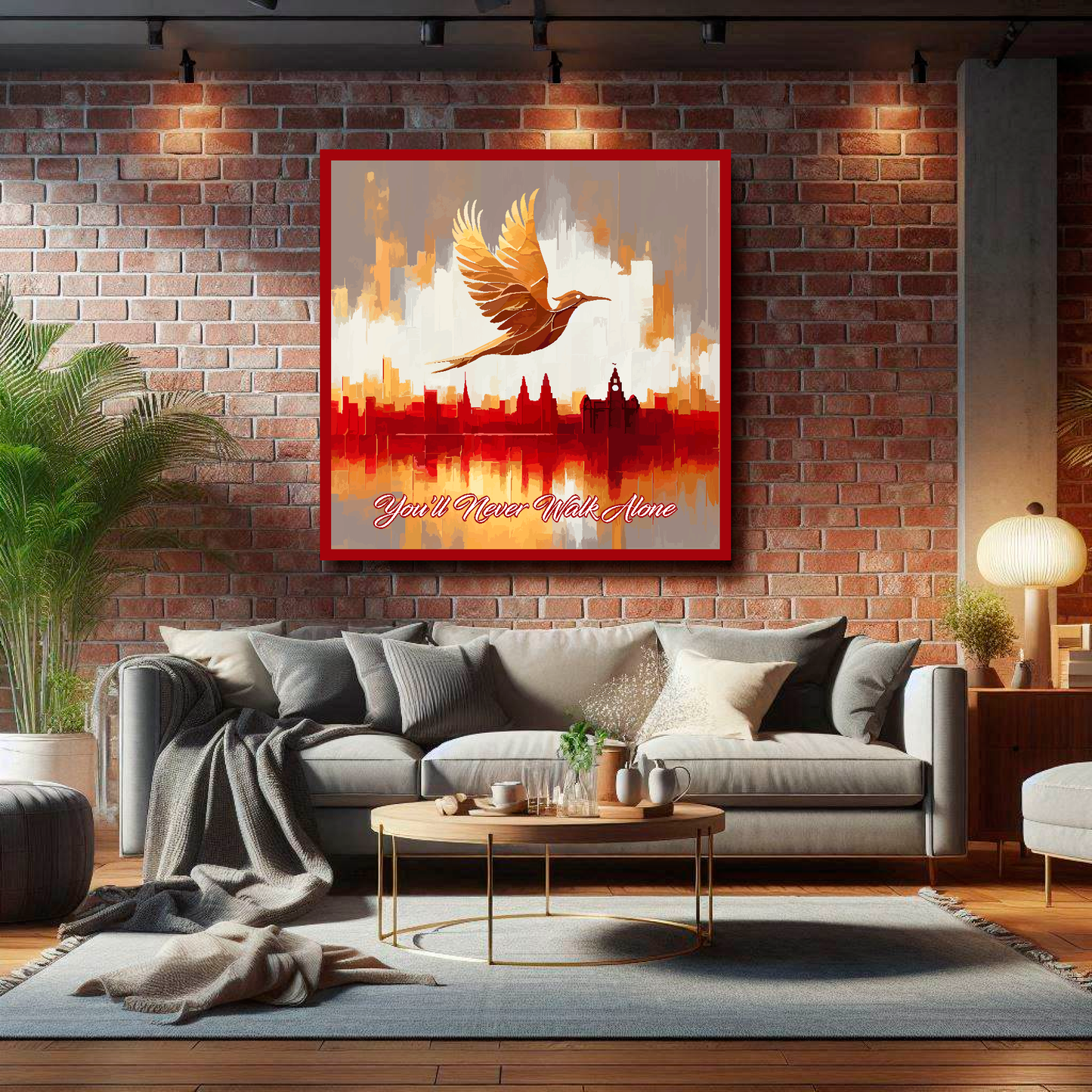 Liverpool FC inspired canvas, mounted on a lounge wall above a grey sofa, featuring a Liver bird flying over a Liverpool skyline with the words 'You'll Never Walk Alone' in red and white.