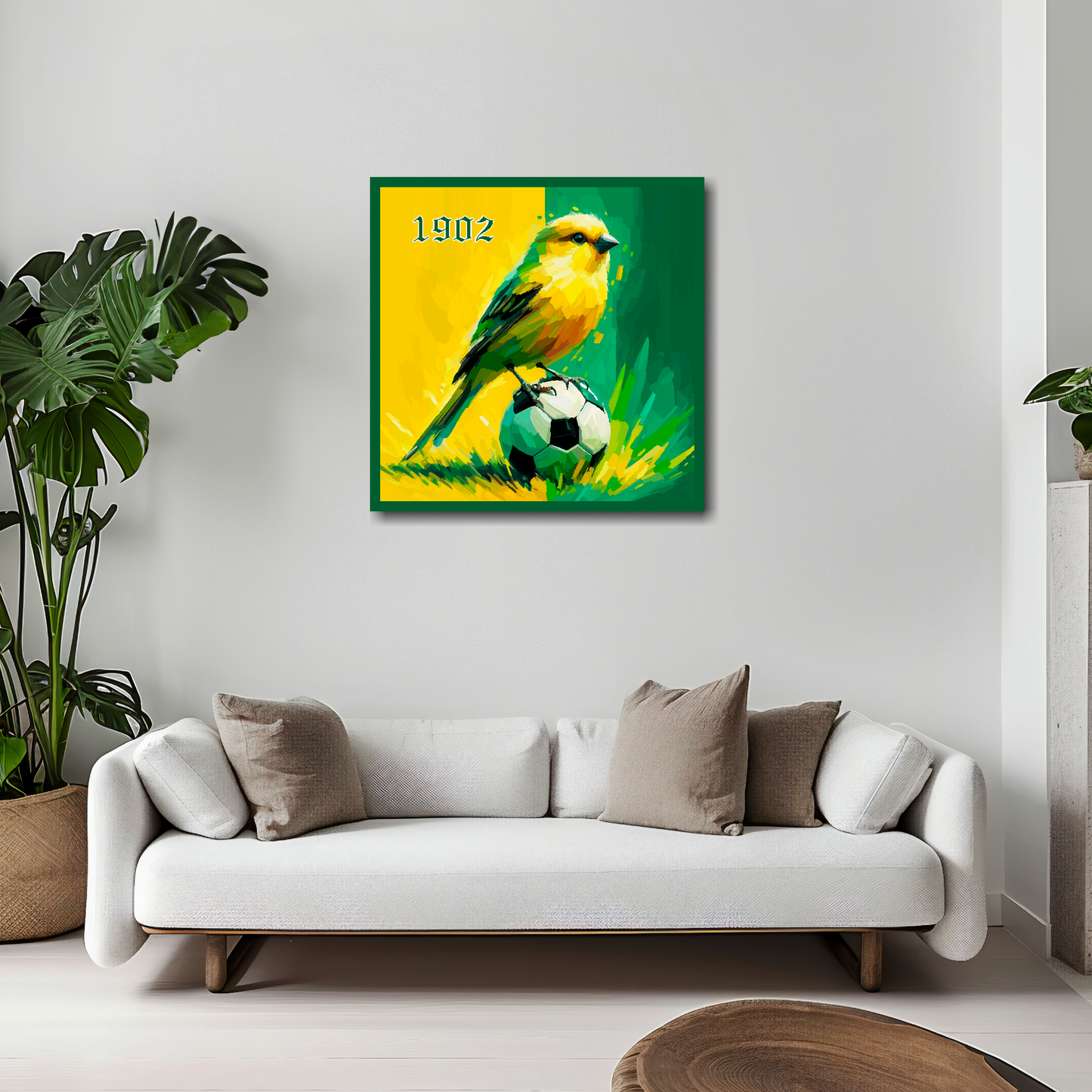 20 inch by 20 inch Norwich City FC inspired canvas, mounted on a living room wall above a white sofa, featuring a Canary sitting on a football on a Yellow and Green background.