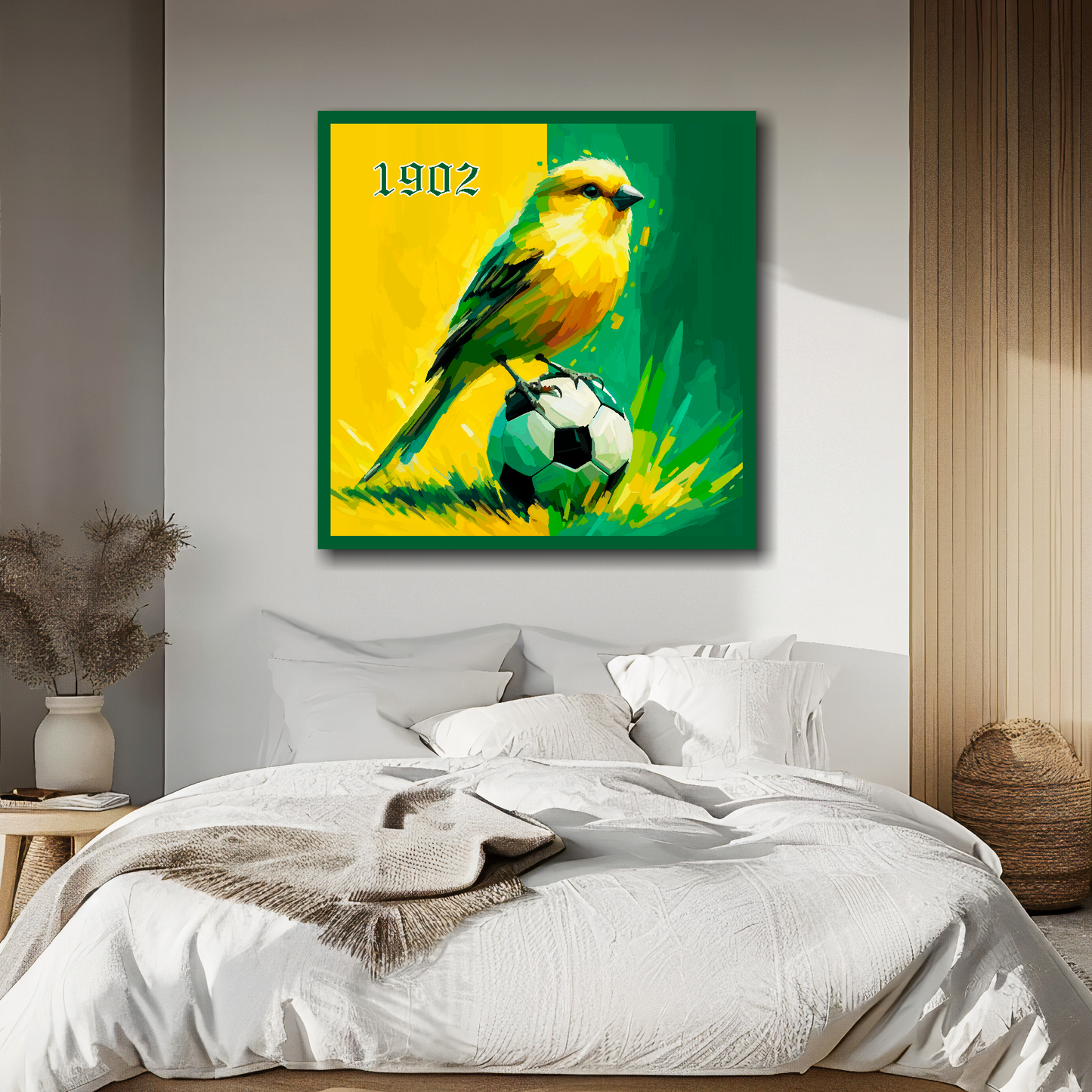 Norwich City FC inspired canvas, mounted on a white bedroom wall above a bed, featuring a Canary sitting on a football on a Yellow and Green halved background. '1902' in top left hand corner.