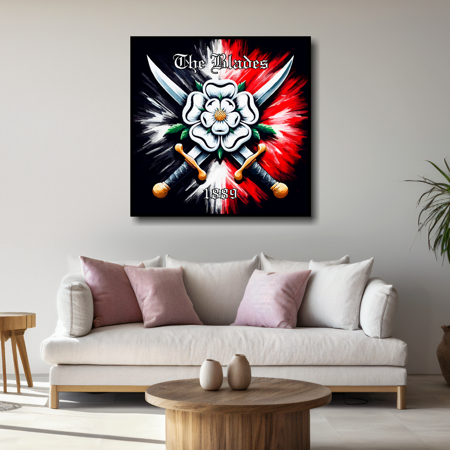 Sheffield United FC inspired canvas, mounted on a living room wall above a white sofa. Featuring two crossed swords with a white Yorkshire rose on a black and red background. 'The Blades' written at the top with '1889' at the bottom.