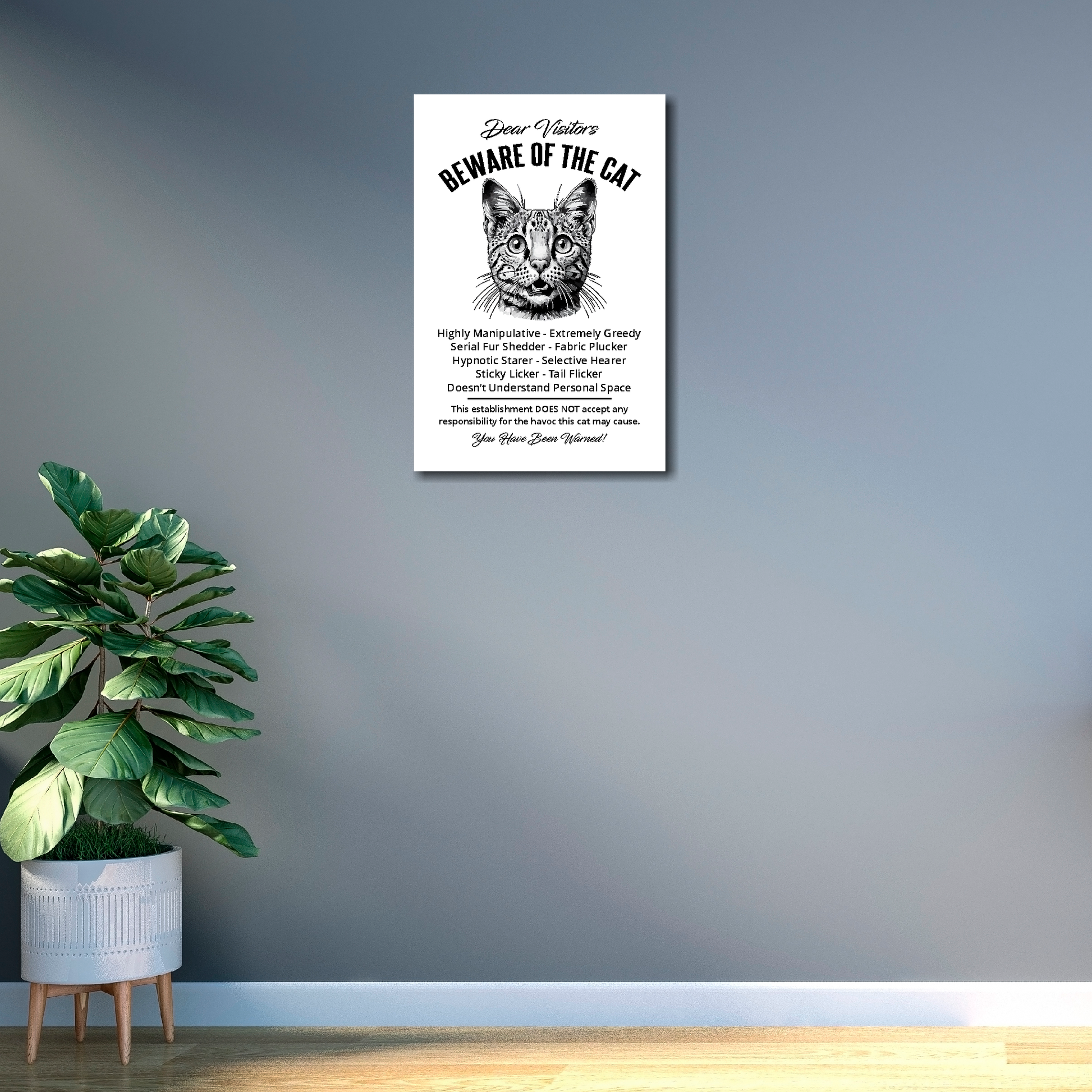 12 inch by 18 inch canvas print of a funny Savannah 'Beware of the cat' notice. Mounted on a gray wall next to a plant.