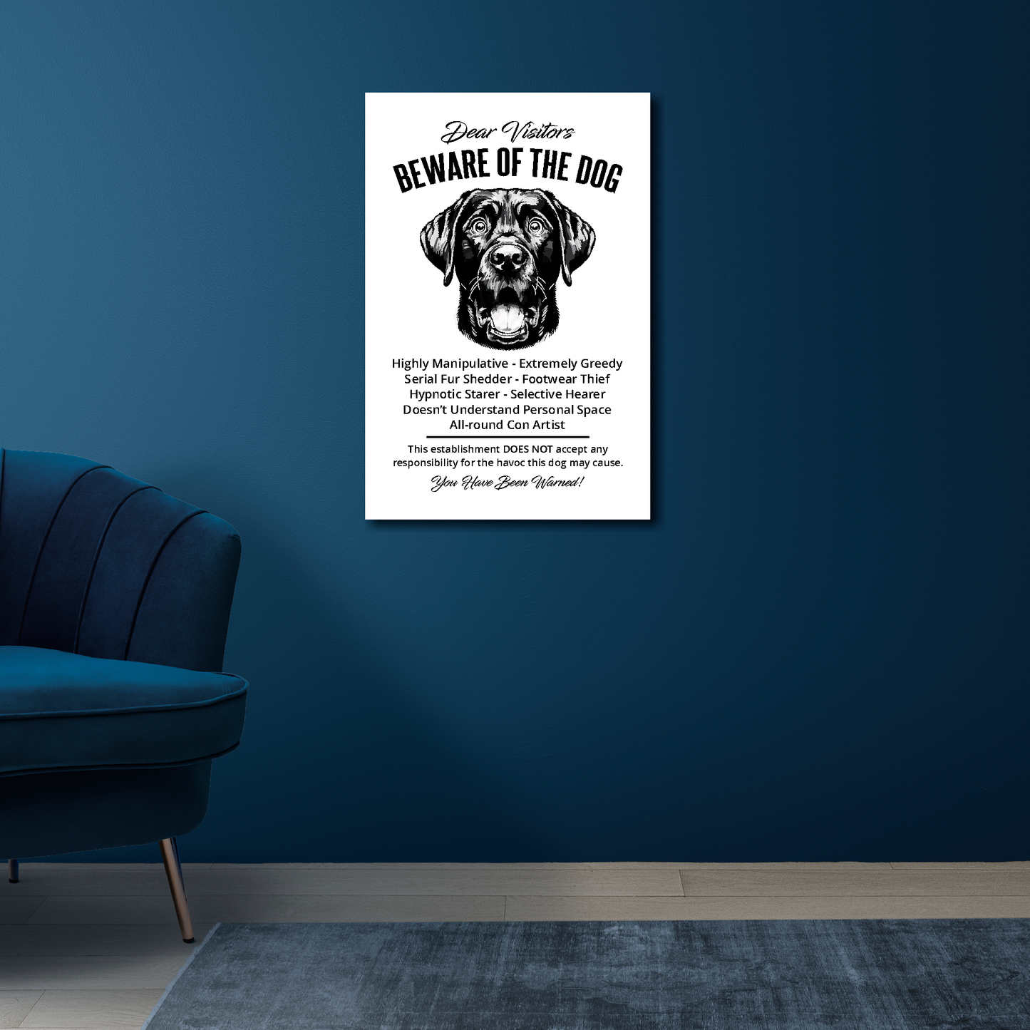 16 inch by 24 inch canvas print of a funny Black Labrador 'Beware of the Dog' notice. Mounted on a blue wall above a blue chair.