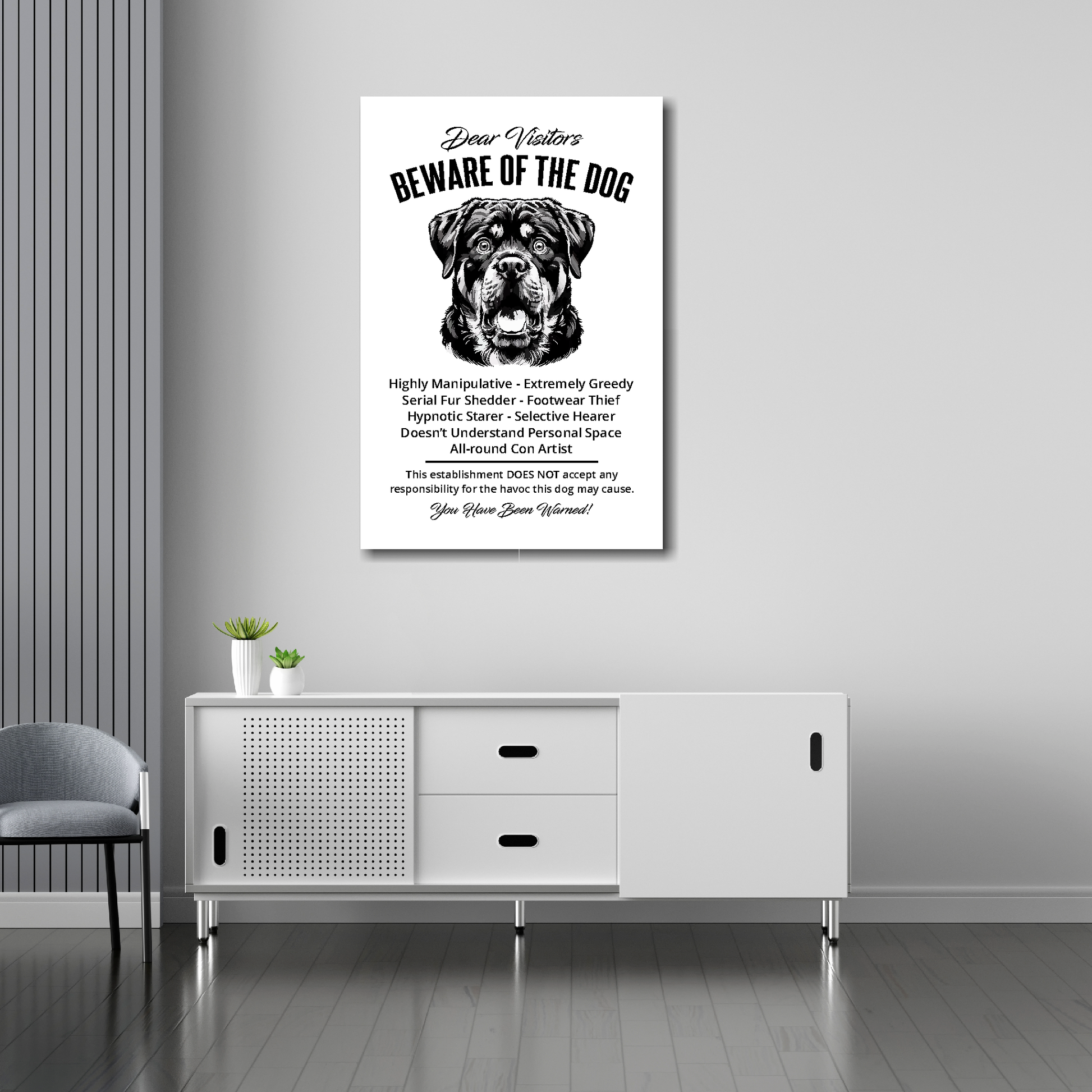 20 inch by 30 inch canvas print of a funny Rottweiler 'Beware of the Dog' notice. Mounted on a gray wall above a white sideboard.