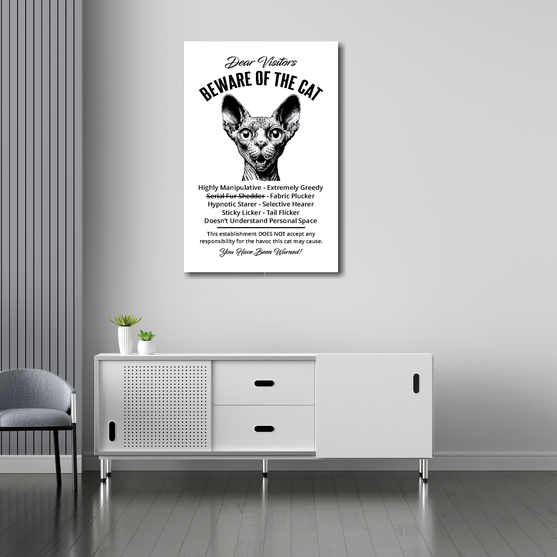20 inch by 30 inch canvas print of a funny Sphynx 'Beware of the cat' notice. Mounted on a gray wall above a white sideboard.