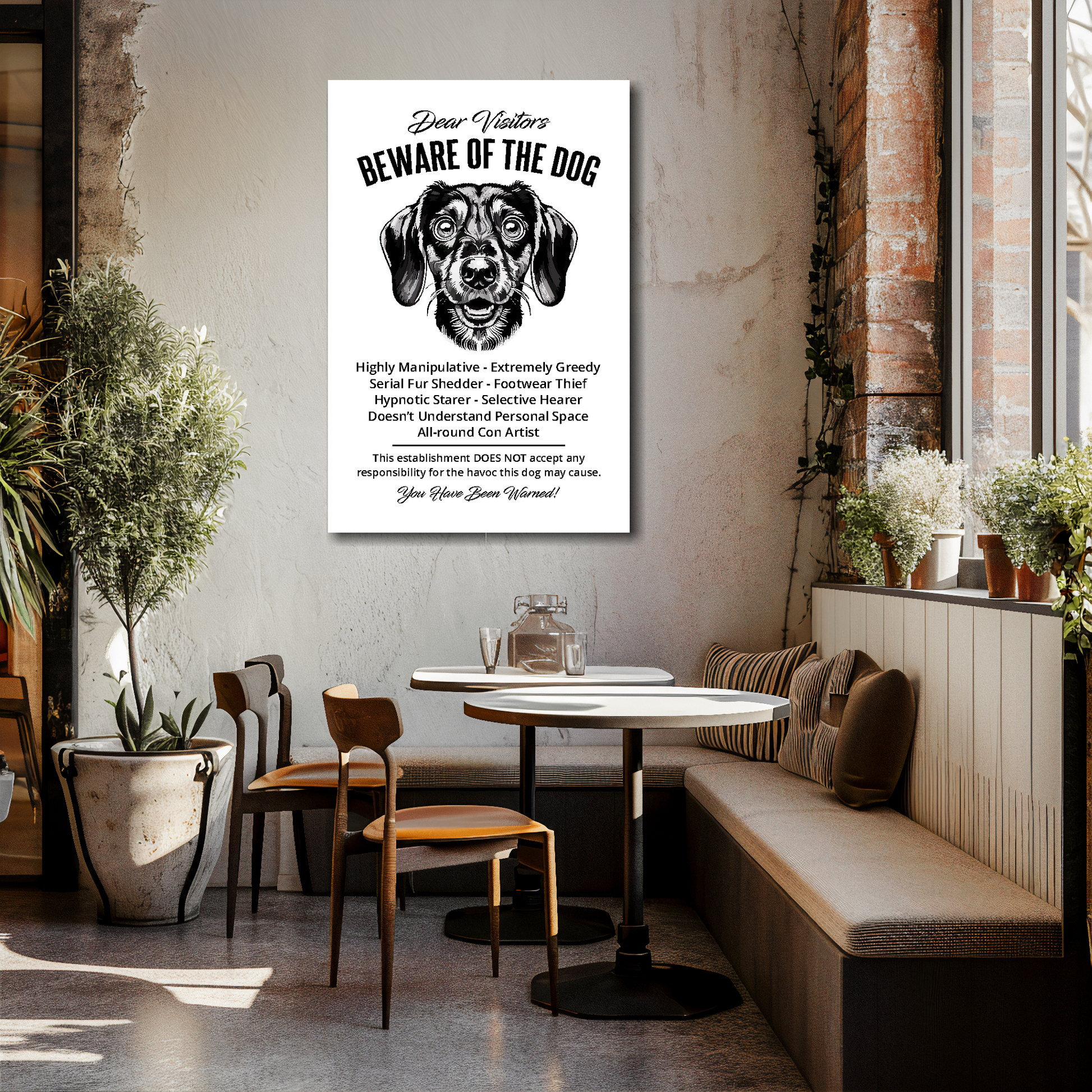 24 inch by 36 inch canvas print of a funny Dachshund 'Beware of the Dog' notice. Mounted on a cream cafe wall above tables and chairs.