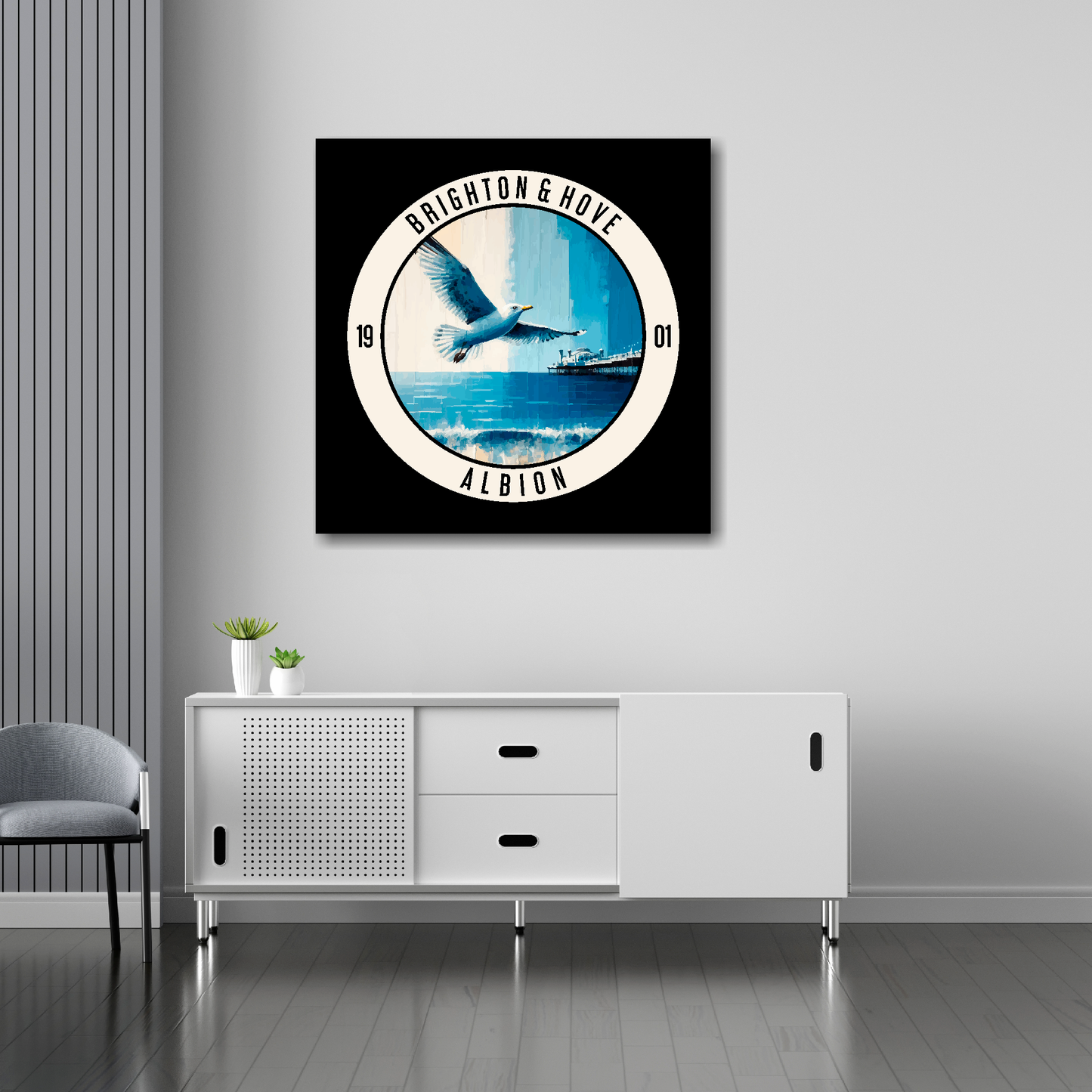 30 inch by 30 inch Brighton FC inspired canvas, featuring a large seagull, beach and pier on black background. Mounted on a white wall above a white sideboard.