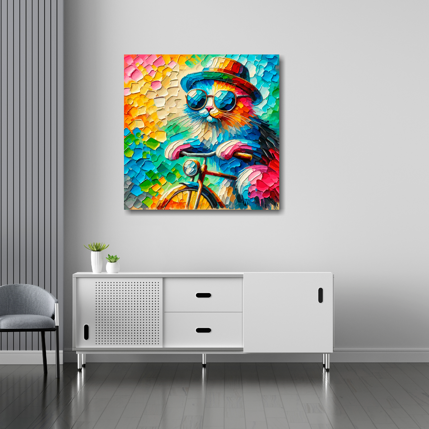 30 inch by 30 inch square canvas featuring a vibrant multi-coloured cool cat riding a bicycle. Mounted on a white wall above a white sideboard.