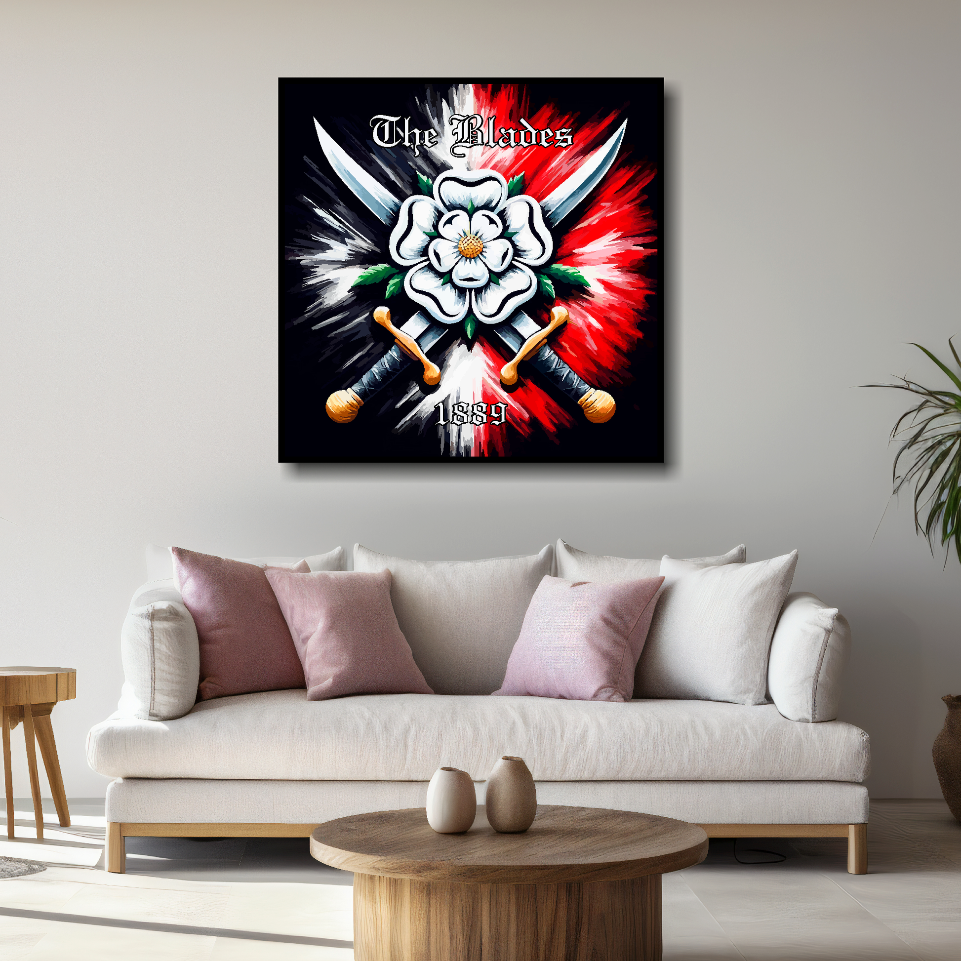 Sheffield United FC inspired canvas, mounted on a living room wall above a white sofa. Featuring two crossed swords with a white Yorkshire rose on a black and red background. 'The Blades' written at the top with '1889' at the bottom.